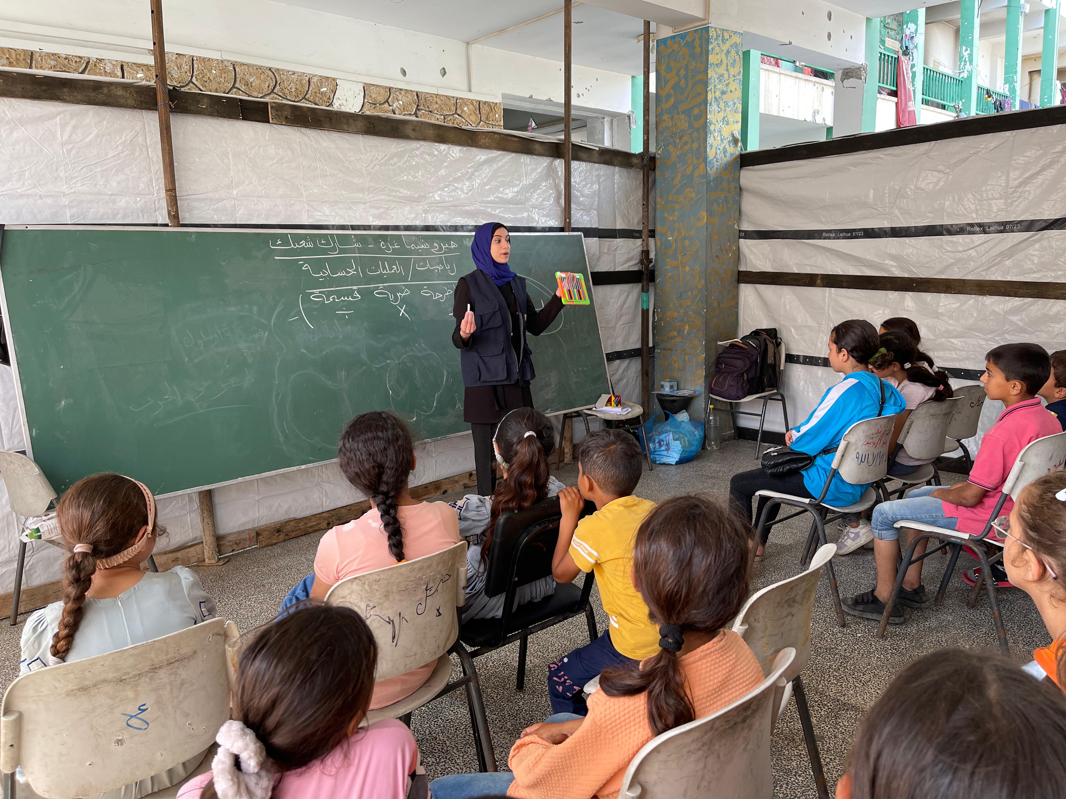 Student in a tent classroom in Gaza
